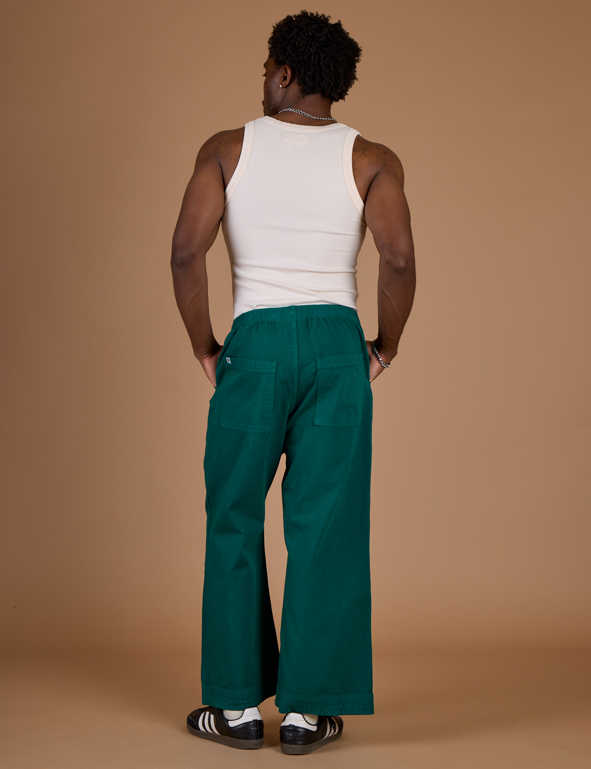 Back view of Isaac in the Hunter Green Action Pant