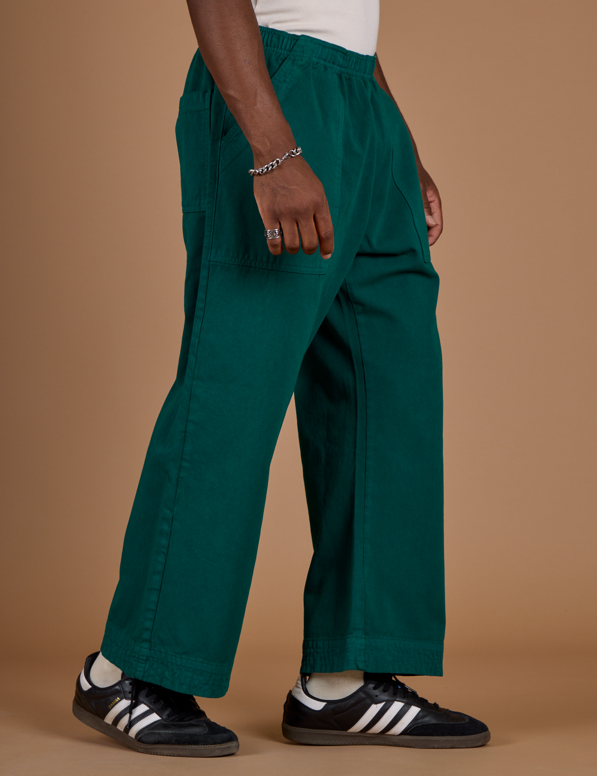 Angled side view of the Hunter Green Action Pant on Isaac