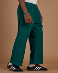 Angled side view of the Hunter Green Action Pant on Isaac