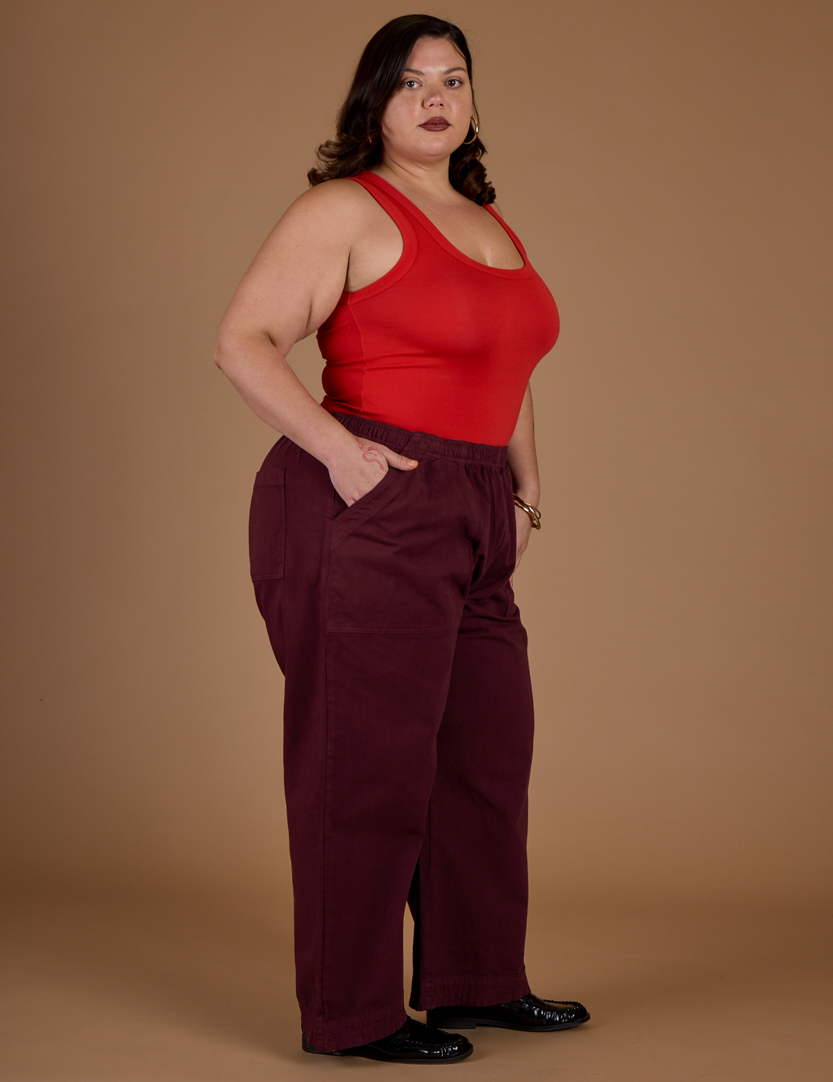 Angled side view of Kristen wearing the Red Wine Action Pant