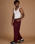 Side view of Isaac in the Red Wine Action Pant