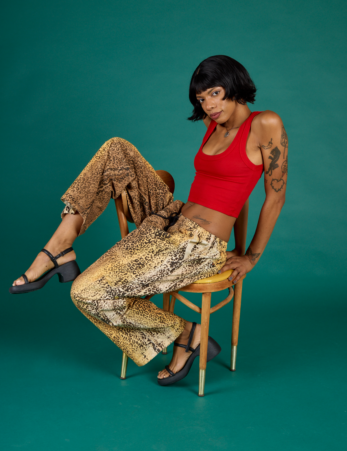 Kira wearing the Leopard Drop Pocket Pant with the Mustang Red Cropped Tank
