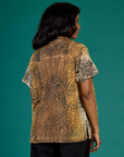 Angled back view of Kandia wearing the Leopard Pantry Button Up