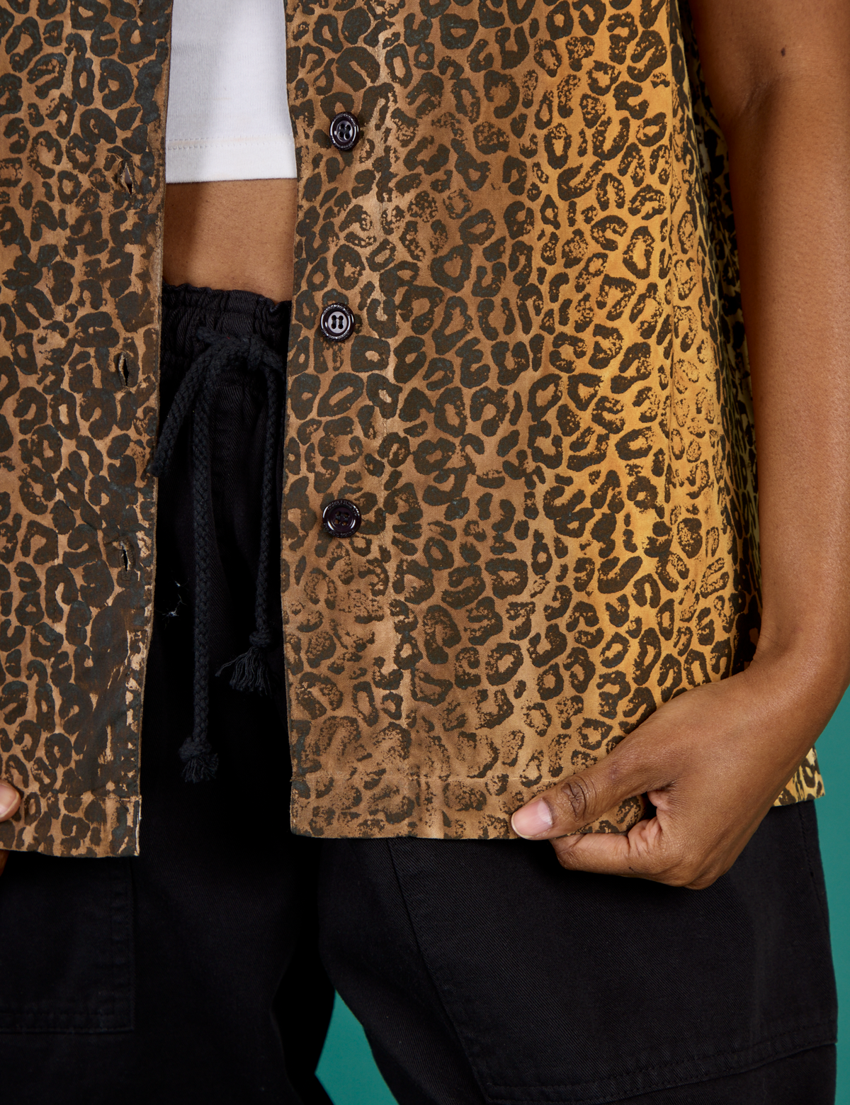 Close up on the buttons and hem of the Leopard Pantry Button Up worn by Kandia