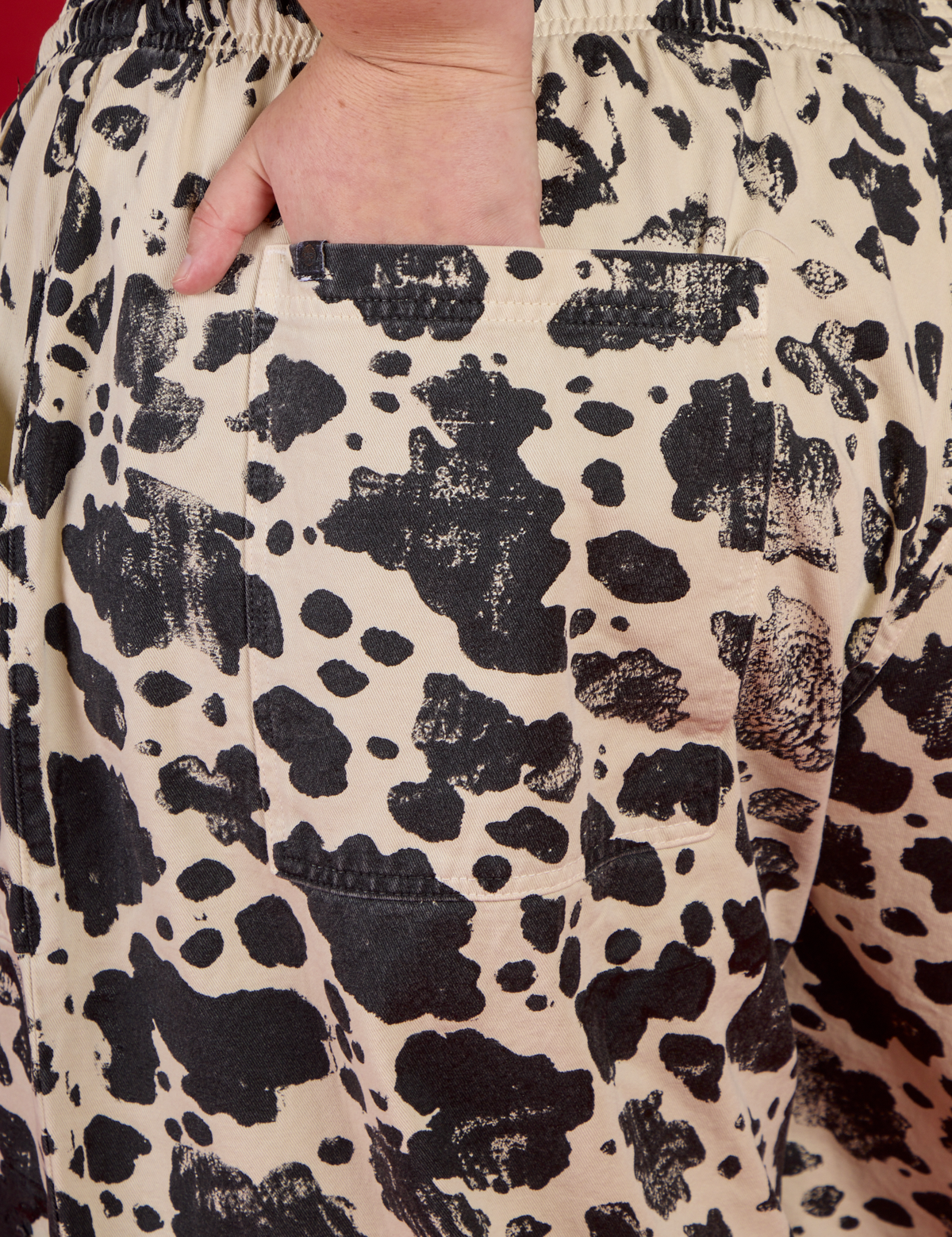 Close up of Juliet's hand in the back pocket of the Cow Drop Pocket Pant