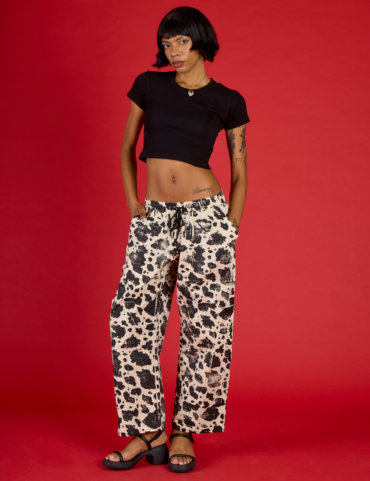 Kira is 5'10" and wearing XS Cow Drop Pocket Pant with Black Cropped Baby Tee
