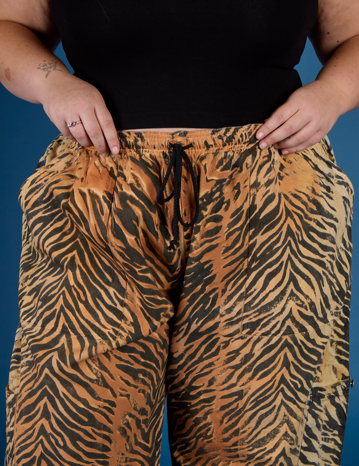 Close up of Juliet's hands on the waistband of the Tiger Drop Pocket Pant
