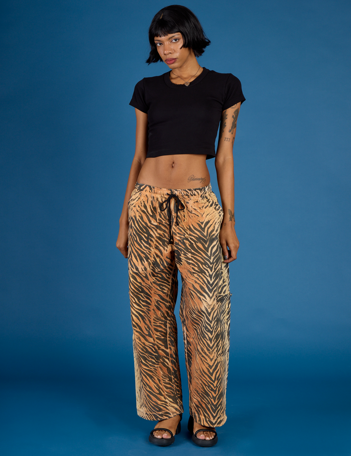 Kira is wearing the Tiger Drop Pocket Pant with the Black cropped Baby Tee