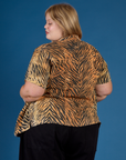 Angled back view of the Tiger Pantry Button Up on Juliet