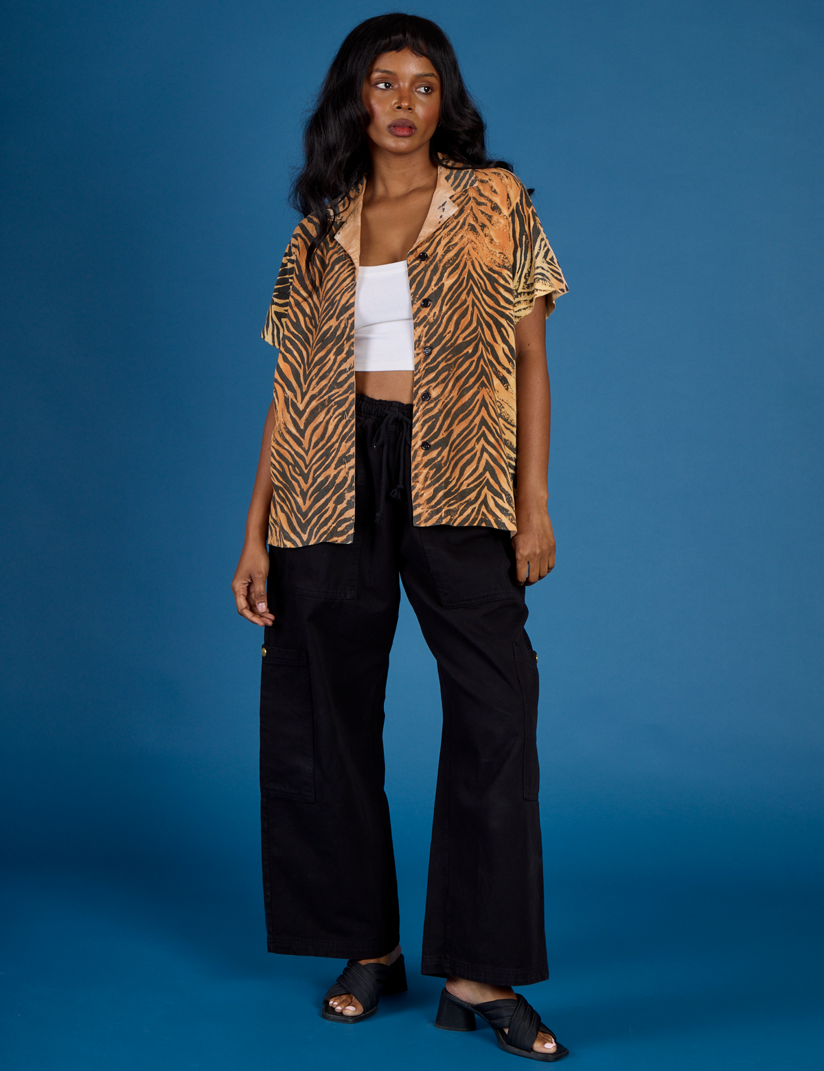 Kandia is wearing the Tiger Pantry Button Up open with the Vintage Tee White Cropped Tank underneath and Black Drop Pocket Pants