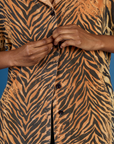 Close up of Kandia buttoning up the Tiger Pantry Button Up