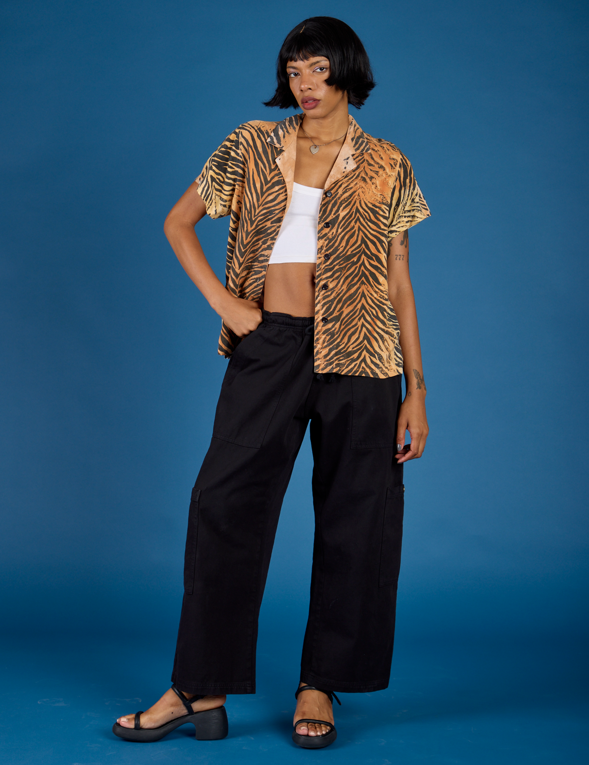 Kira is 5'10" and wearing the Tiger Pantry Button Up