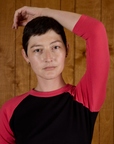 Close up of Alex in the Black/Pink Colorblock Raglan Tee