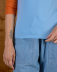 Close up of hem on the Baby Blue/Orange Colorblock Raglan Tee worn by Alex