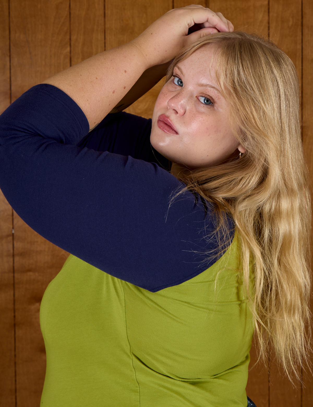 Close up side view of Juliet wearing the Gross Green/Navy Colorblock Raglan Tee