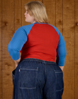 Angled back view of the Mustang Red/Blue Colorblock Raglan Tee on Juliet