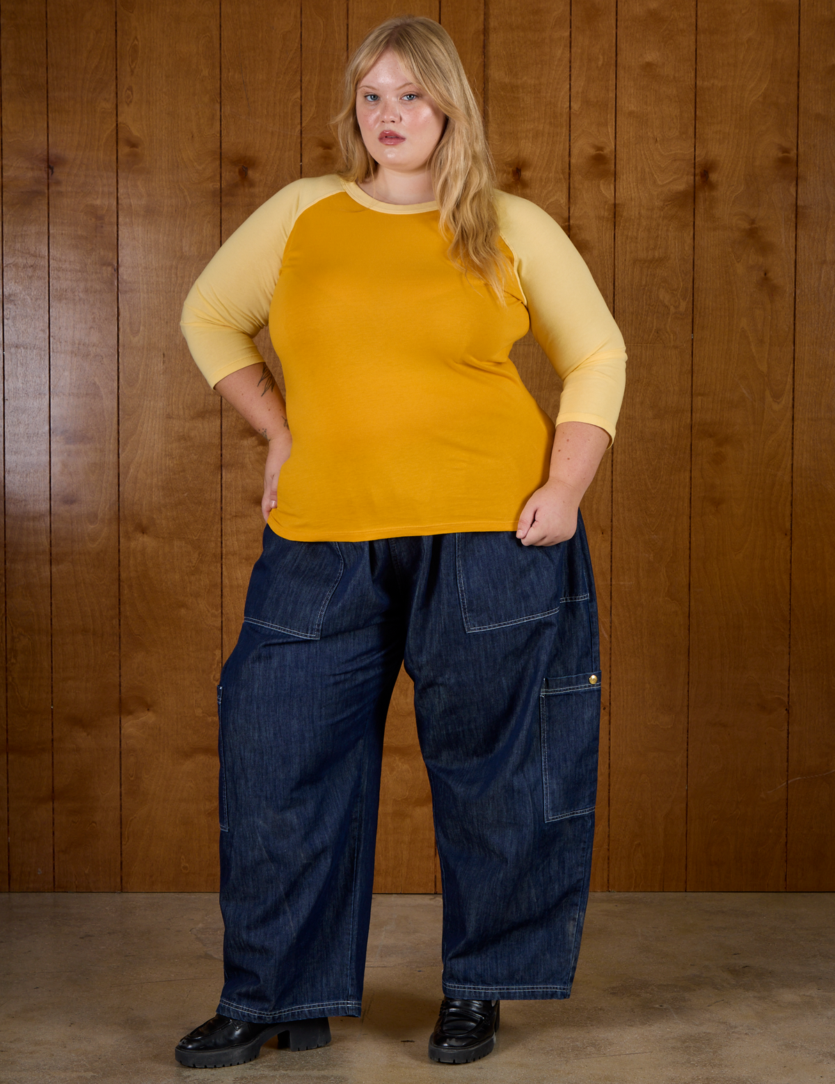 Juliet wearing the Mustard Yellow/Butter Raglan Tee untucked with Dark Wash Denim Drop Pocket Pants