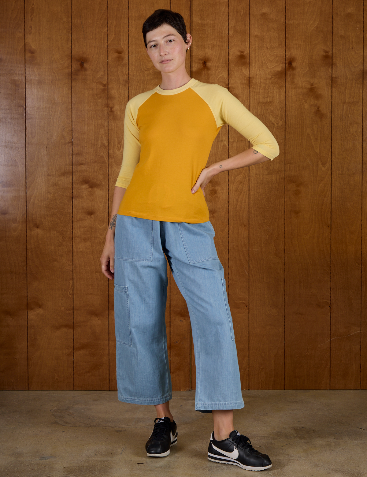 Alex is 5'8" and wearing P Mustard Yellow/Butter Raglan Tee untucked with Light Wash Denim Drop Pocket Pants