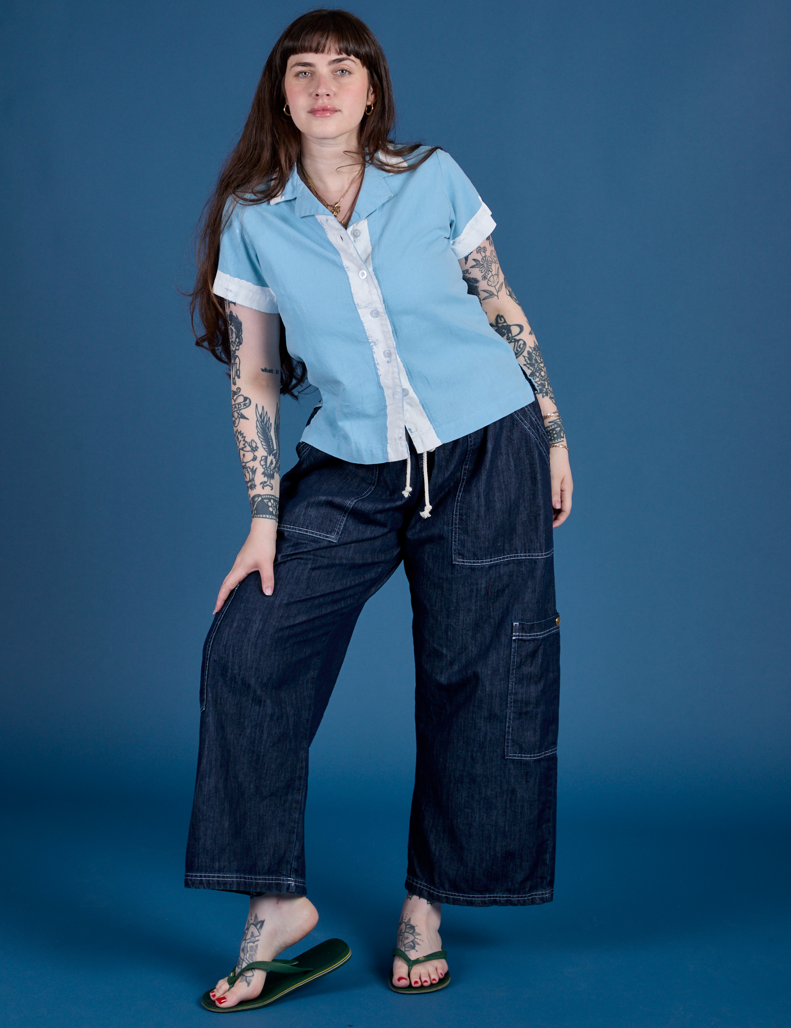 Sydney is wearing Painted Pantry Button-Up in Baby Blue and dark wash Drop Pocket Cargo Pants