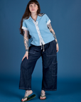 Sydney is wearing Painted Pantry Button-Up in Baby Blue and dark wash Drop Pocket Cargo Pants