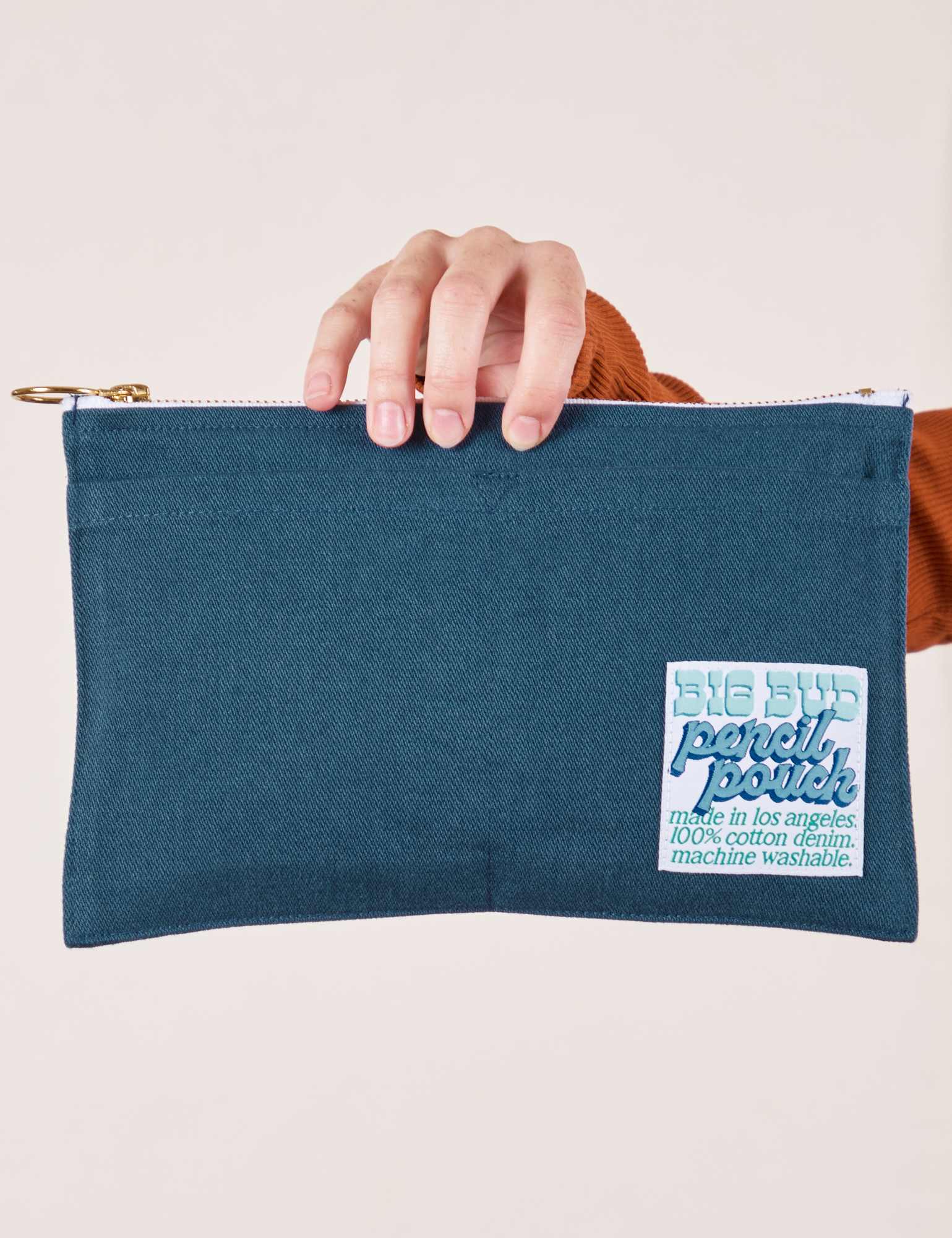 Perfect Pencil Pouch in Lagoon held at the top by model