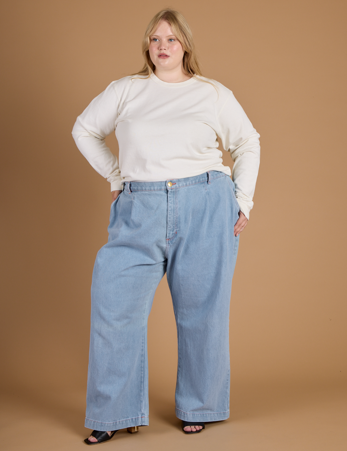 Juliet wearing the Vintage Tee White Long Sleeve Burly Tee tucked into the Light Wash Wide Leg Denim Trousers