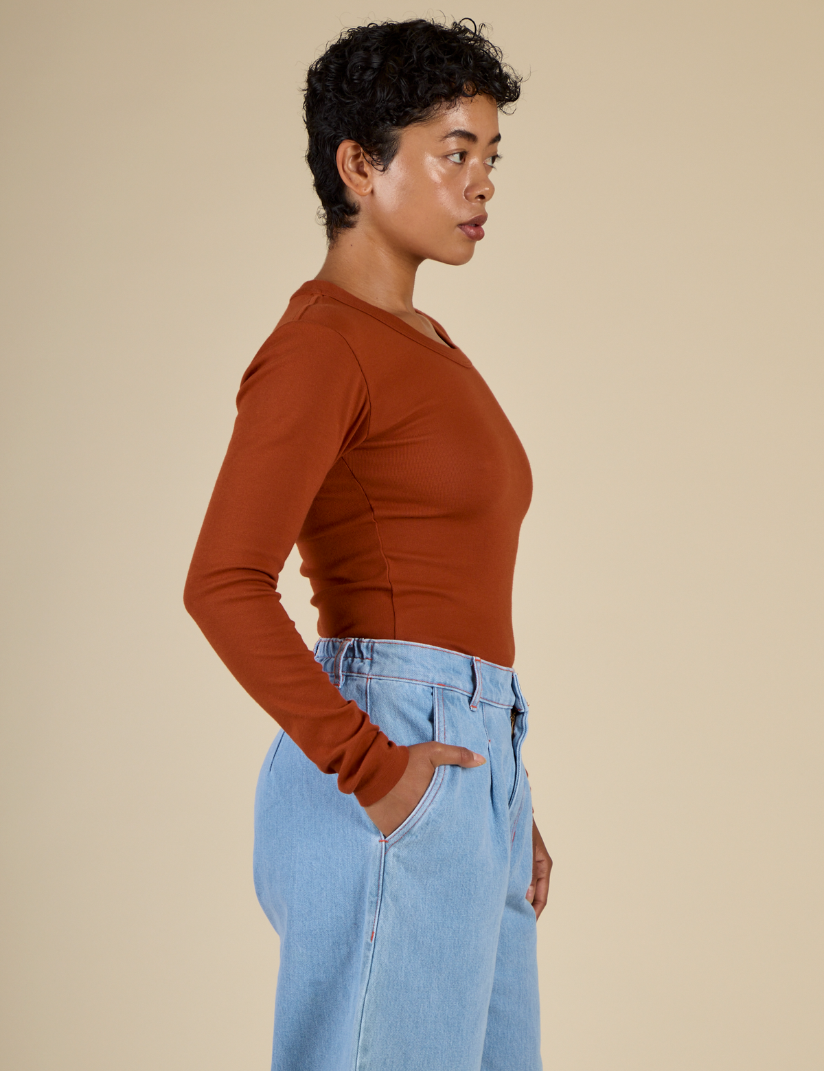 Side view of Mika in the Burnt Terracotta Long Sleeve Baby Tee