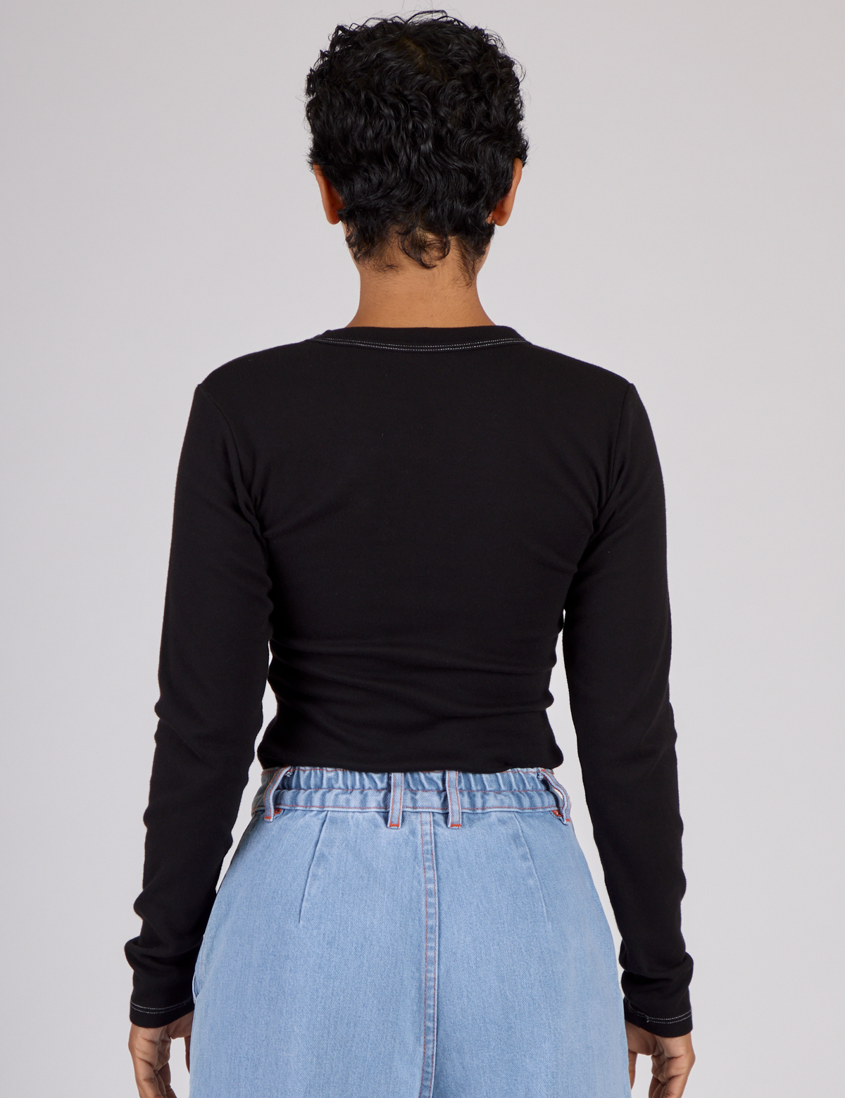 Back view of Mika wearing the Black Porthole Long Sleeve Tee