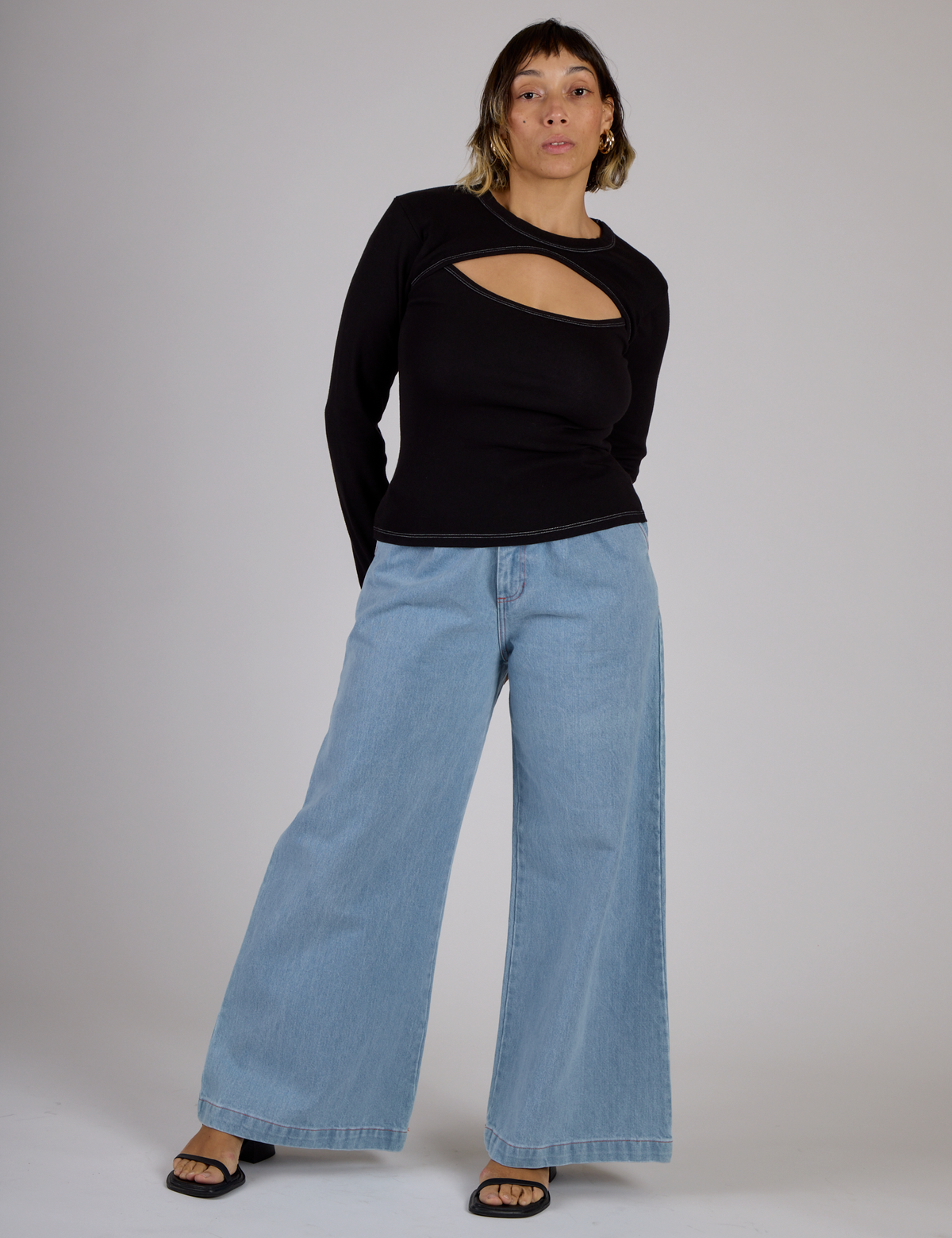 Tiara wearing the Black Porthole Long Sleeve Tee with Light Wash Wide Leg Denim Trousers