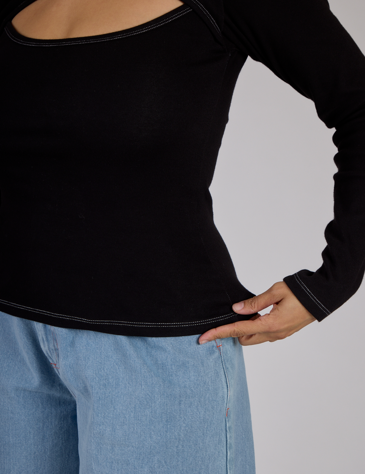 Close up of the Black Porthole Long Sleeve Tee's hem worn by Tiara
