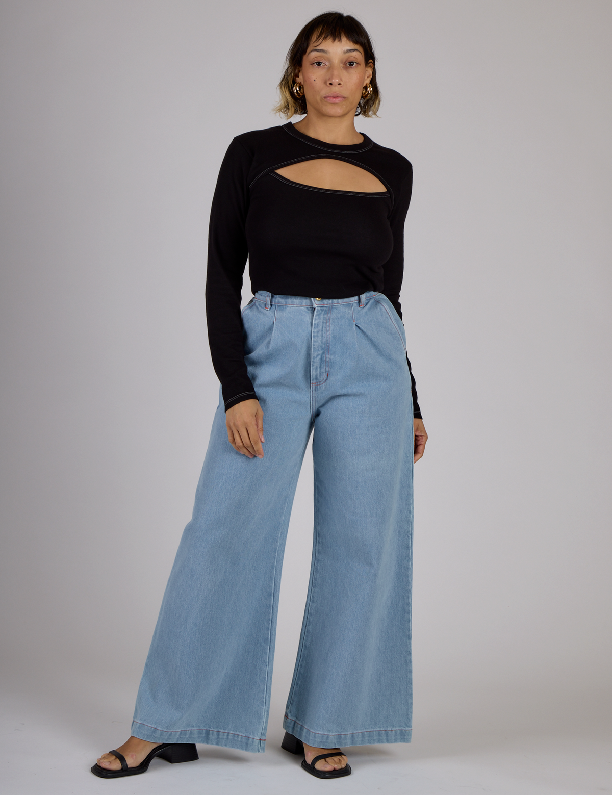 Tiara wearing the Black Porthole Long Sleeve Tee tucked into the Light Wash Wide Leg Denim Trousers