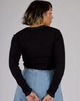 Back view of Tiara wearing the Black Porthole Long Sleeve Tee