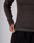 Close up of the Espresso Brown Long Sleeve Porthole Tee's hem worn by Mika