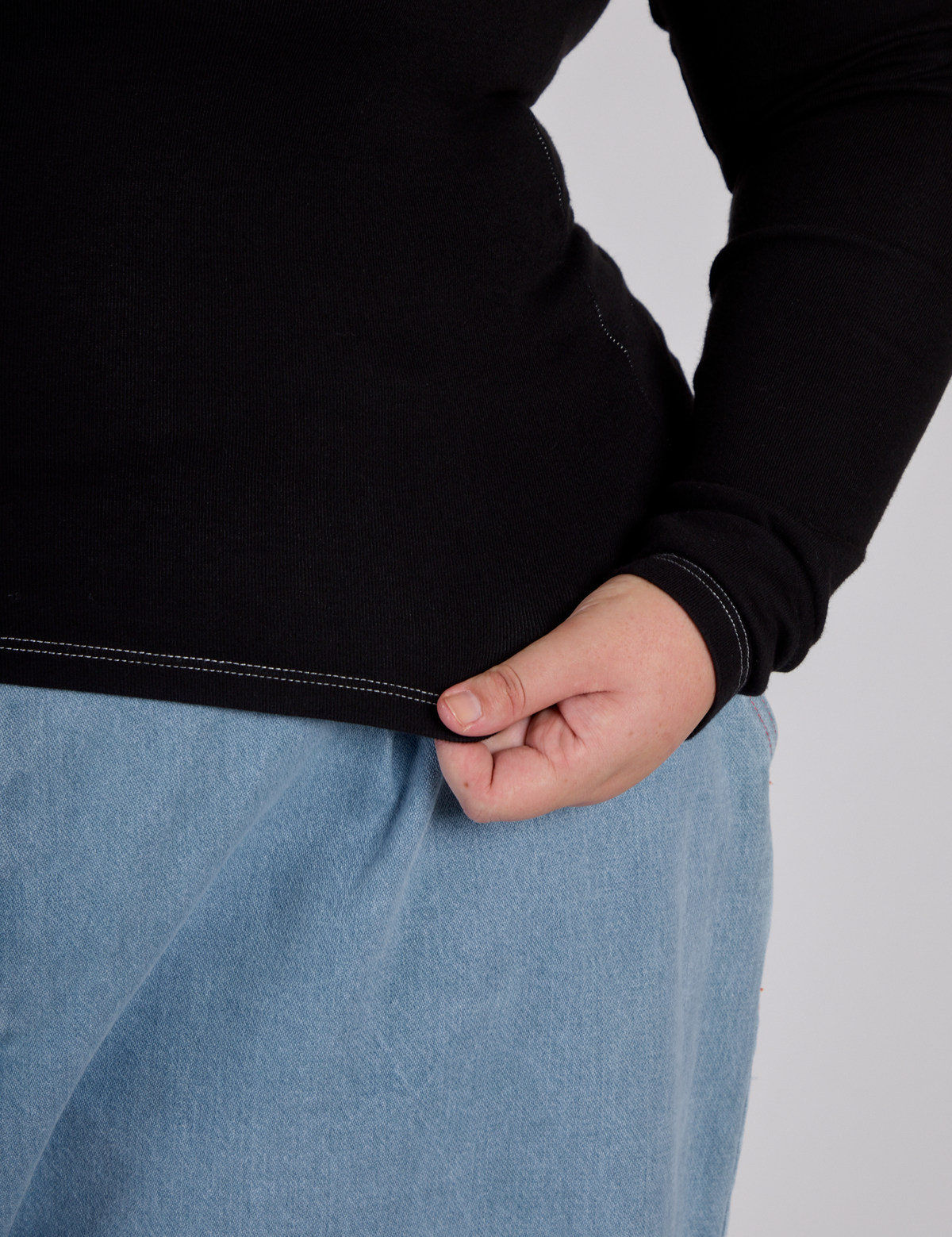 Close up of the Black Porthole Long Sleeve Tee's hem worn by Juliet