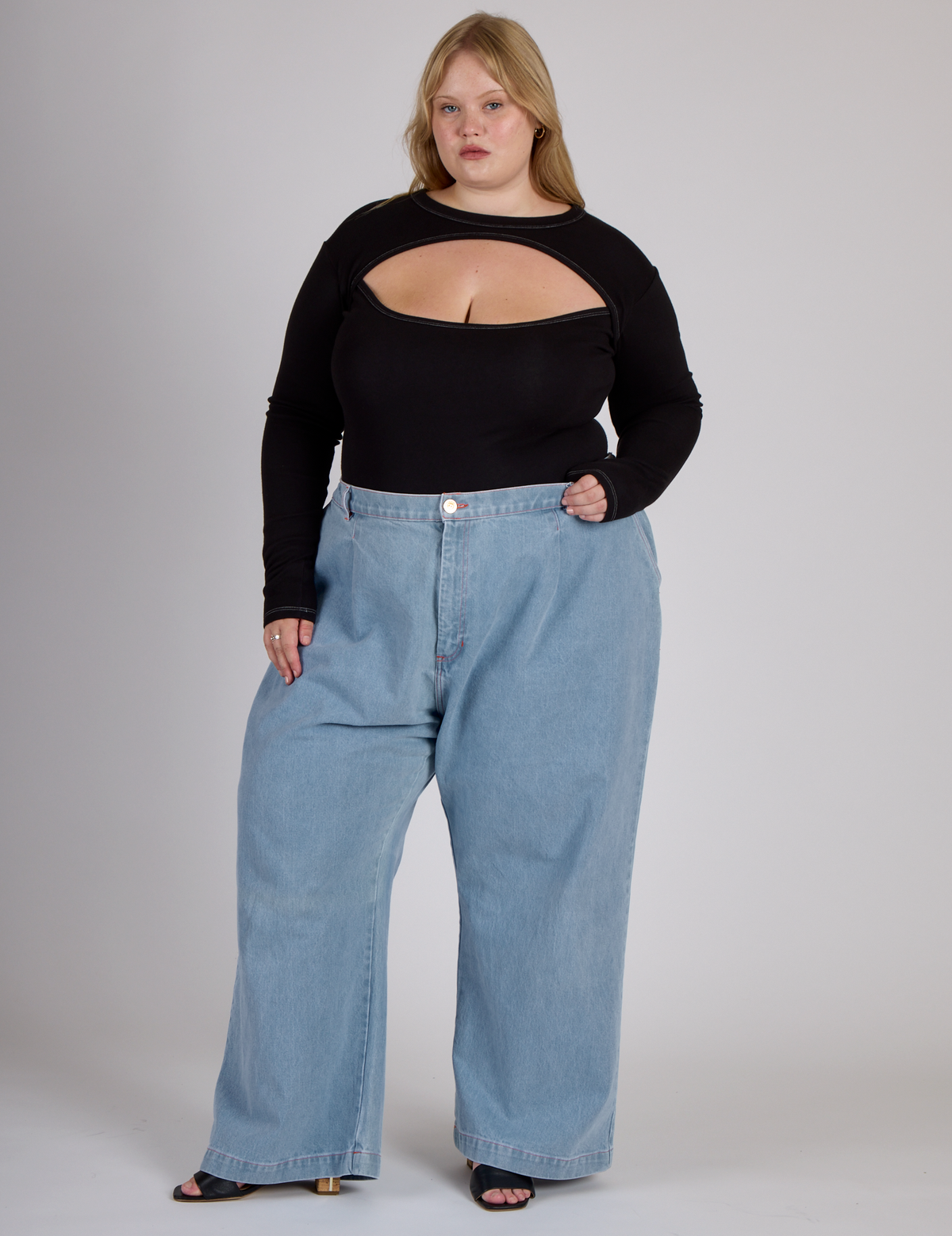 Juliet wearing the Black Porthole Long Sleeve Tee tucked into the Light Wash Wide Leg Denim Trousers