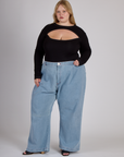Juliet wearing the Black Porthole Long Sleeve Tee tucked into the Light Wash Wide Leg Denim Trousers