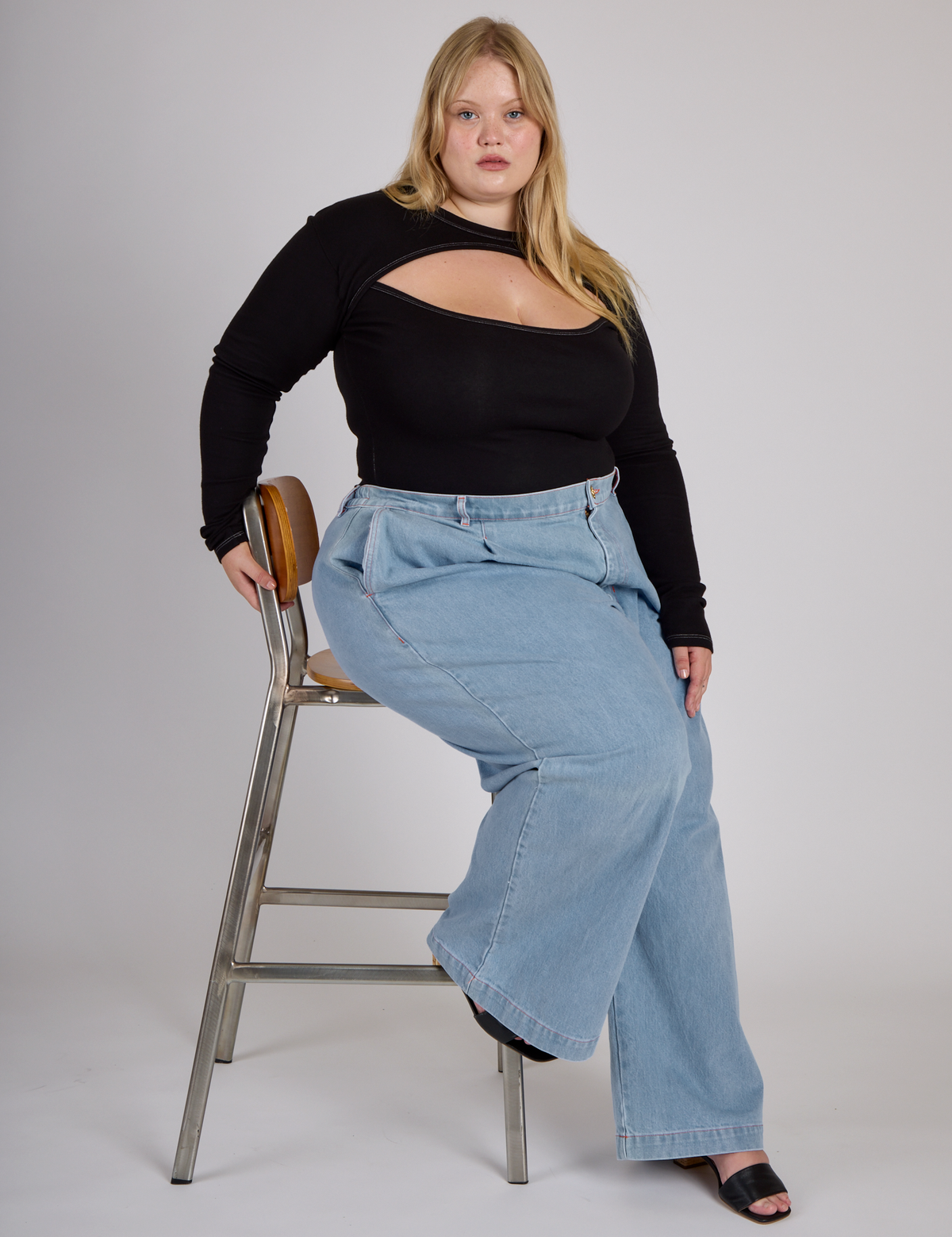 Juliet wearing the Black Porthole Long Sleeve Tee tucked into the Light Wash Wide Leg Denim Trousers
