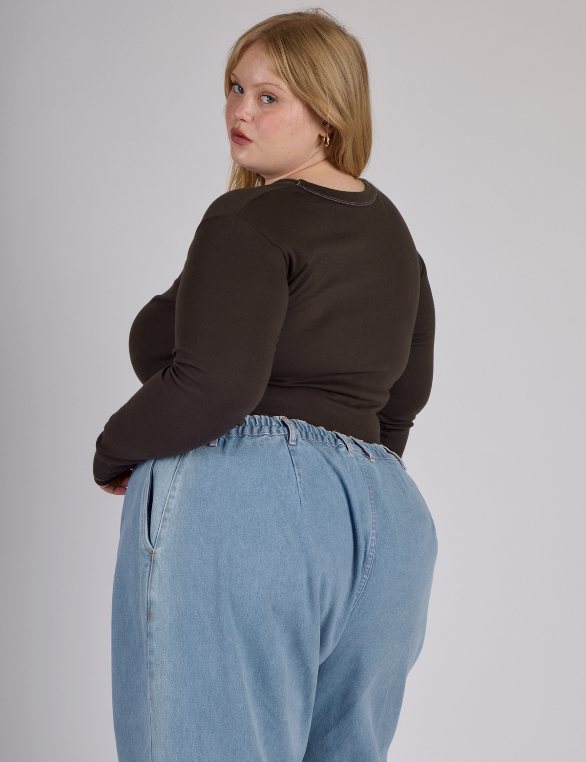 Angled back view of Juliet wearing the Espresso Brown Long Sleeve Porthole Tee