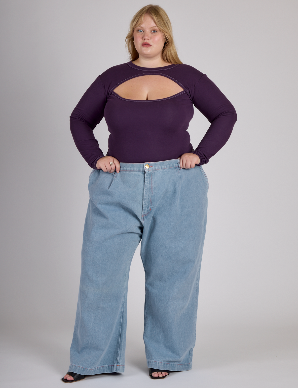 Juliet wearing the Nebula Purple Long Sleeve Porthole Tee tucked into the Light Wash Wide Leg Denim Trousers