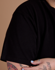 Close up of Burly Tee in Basic Black sleeve on Sam