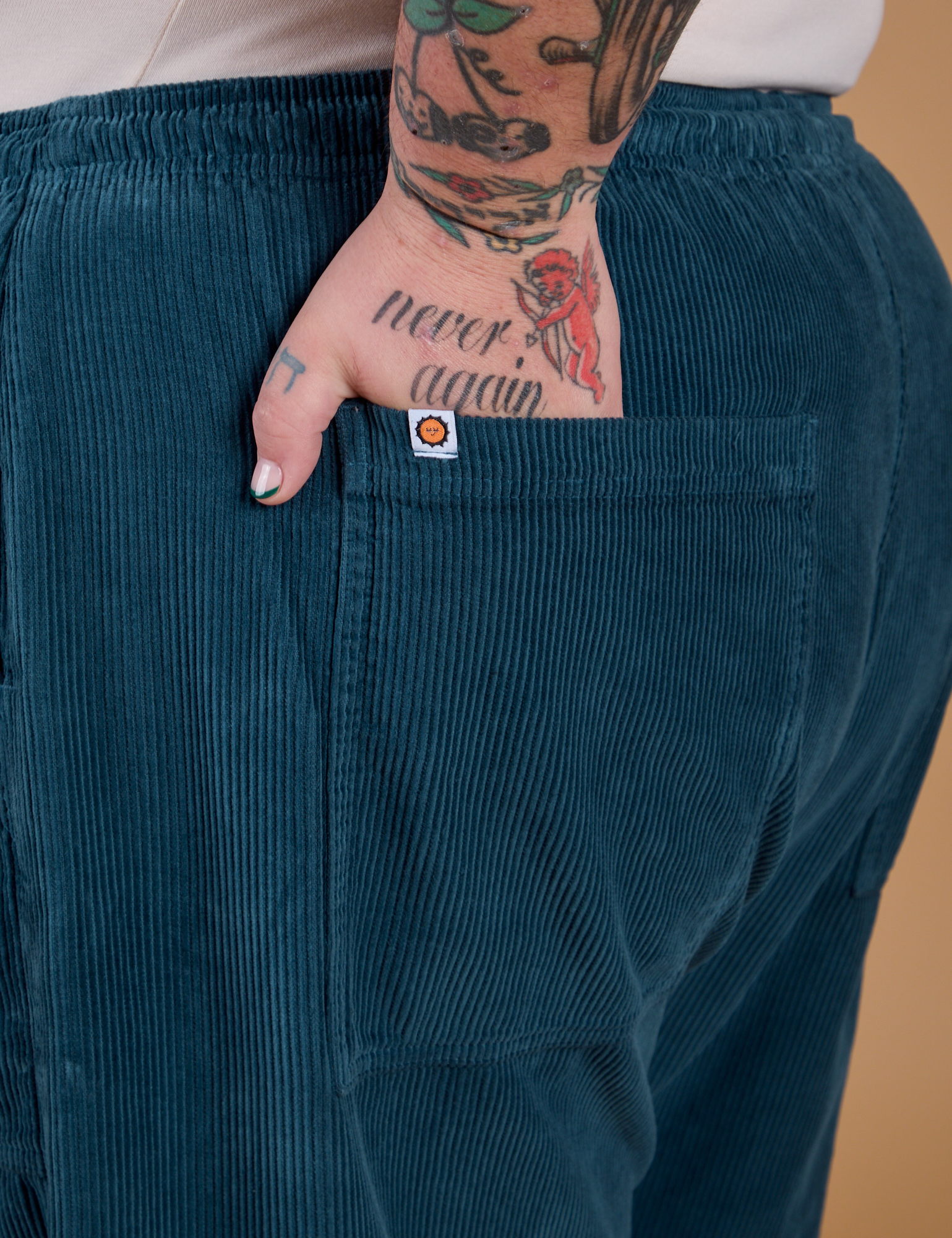 Close up of Sam's hand in the back pocket of Corduroy Drop Pocket Cargo Pants in Lagoon