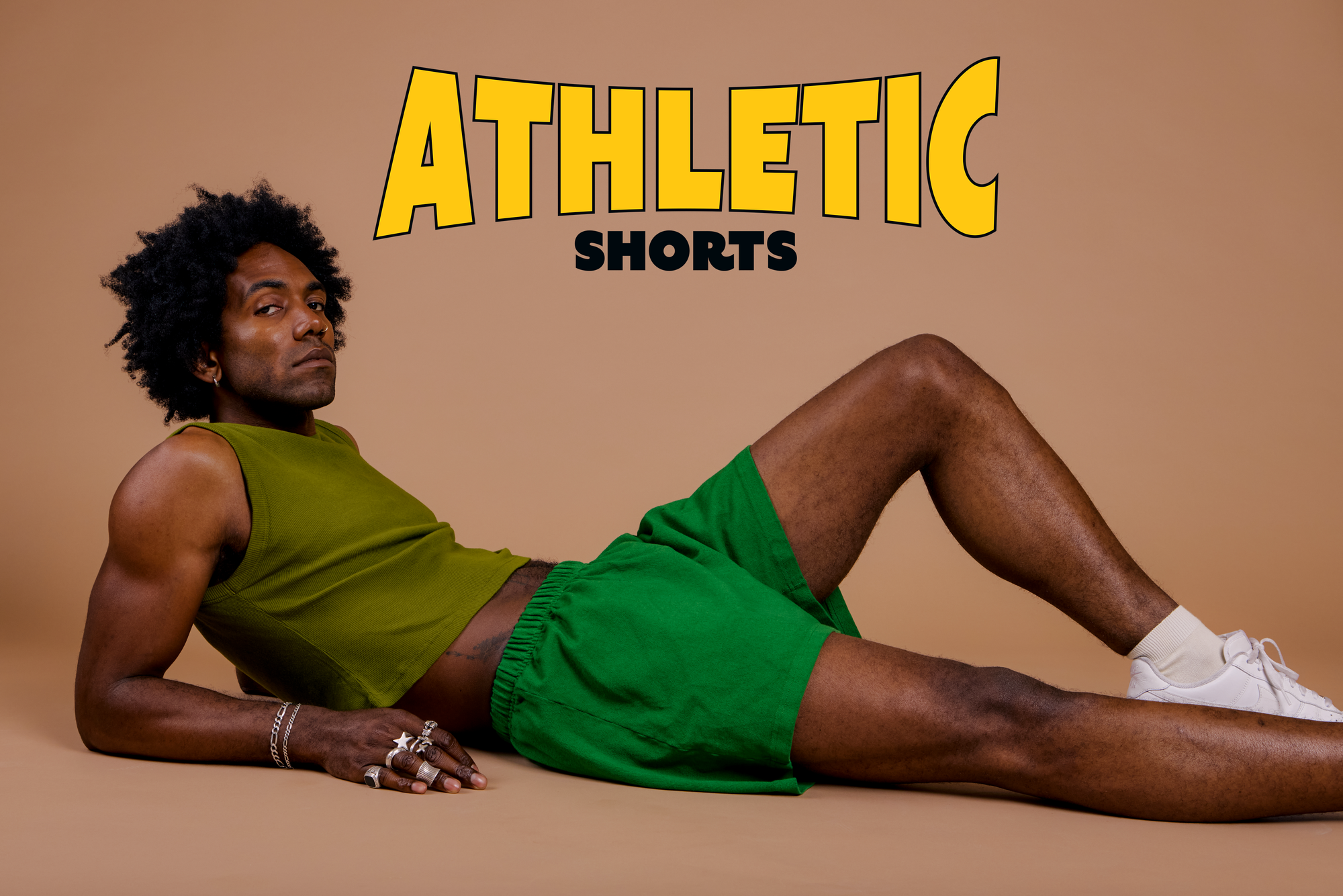 Jerrod is wearing Athletic Shorts in Kelly Green paired with a summer olive Muscle Tee