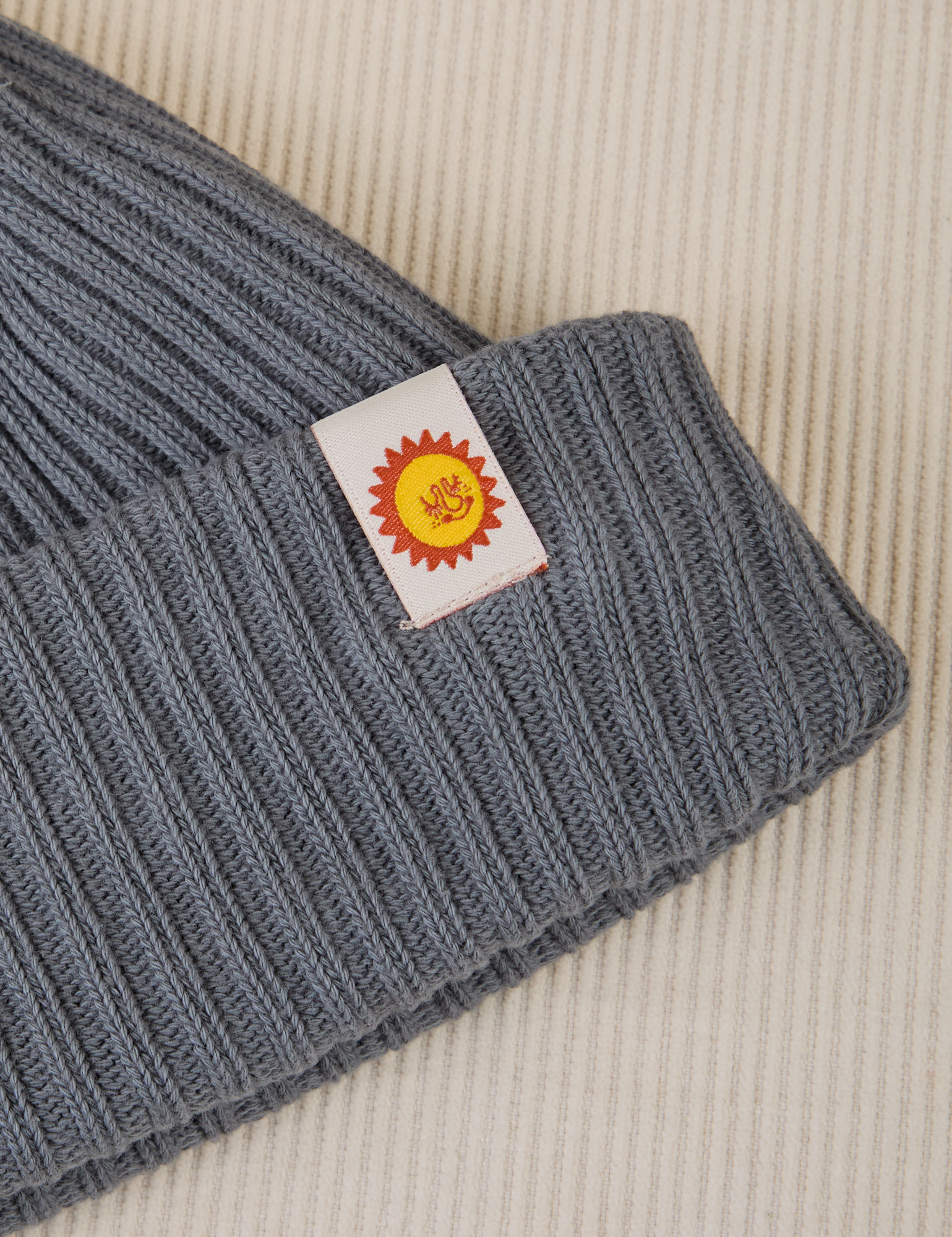 Ribbed Beanie in Slate Grey close up of sun baby tag